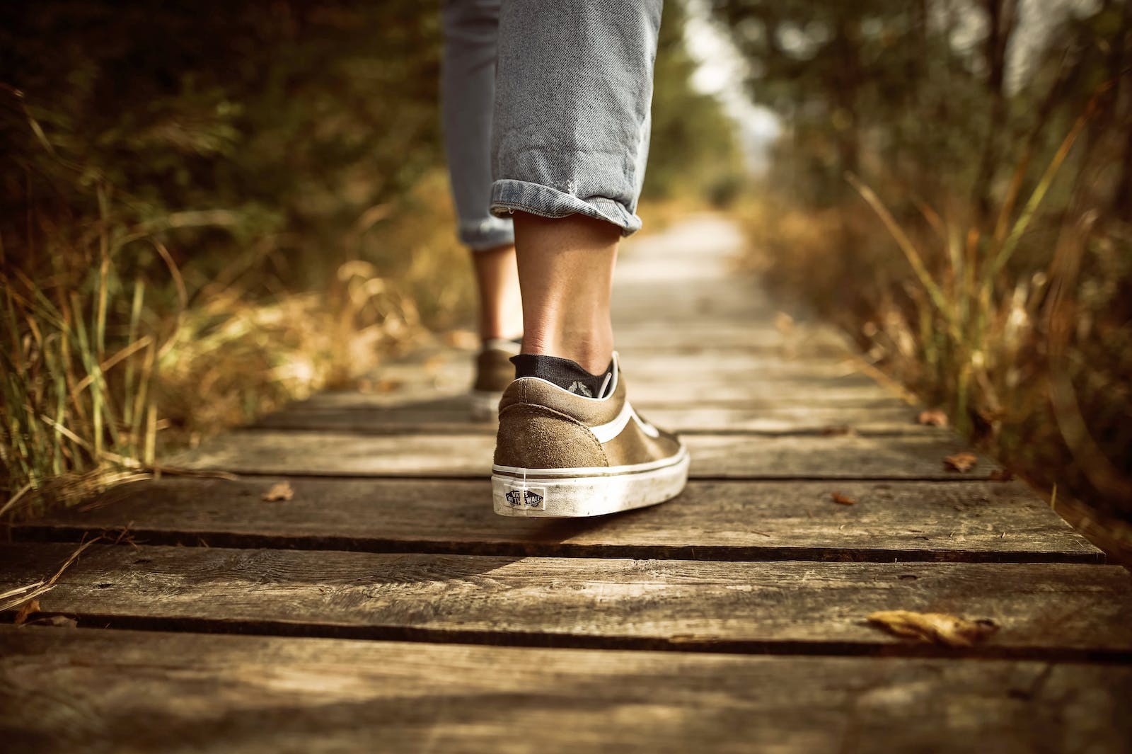 A Divorced Person Moving Forward This is an image of a person walking on a wooden pathway.