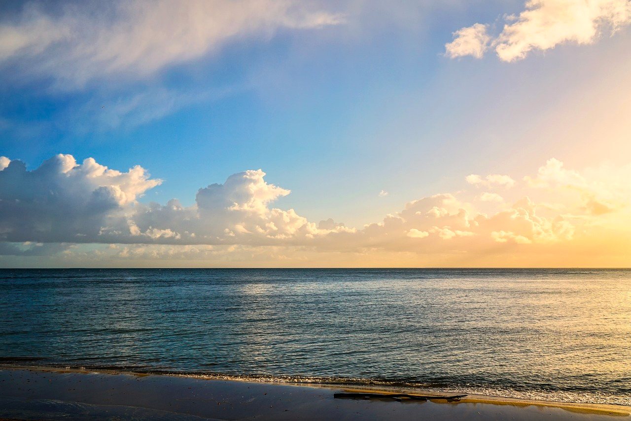 Peaceful shoreline with scattered clouds