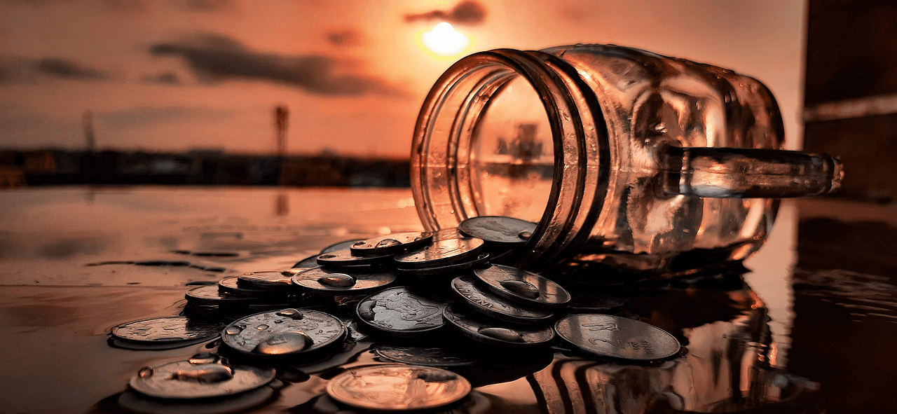 Coin Jar in the Sunset A jar of coins poured on the floor in the sunset