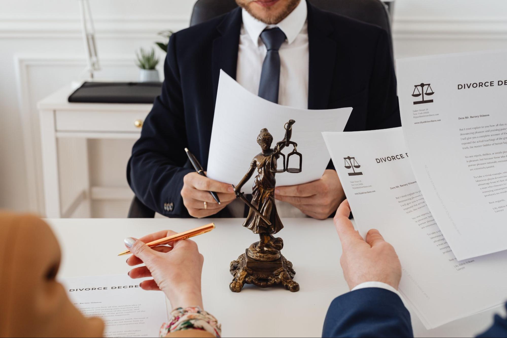 This is an image of divorce paperwork and Lady Justice.