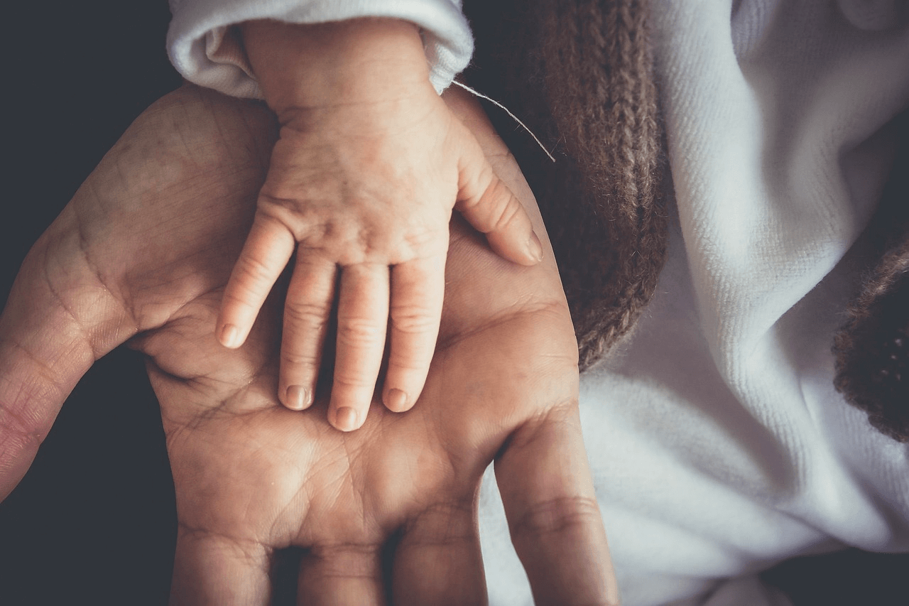 Father and child's hands together Image of a small child's hand with their father's hand