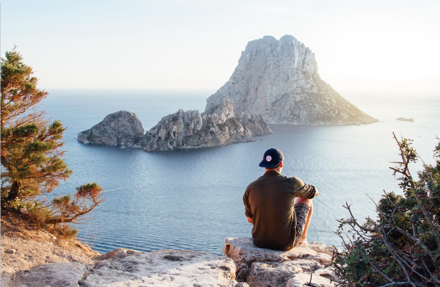 Pros and Cons of Trial Separation This is an image of a person sitting at a cliff's edge, gazing out over the ocean.