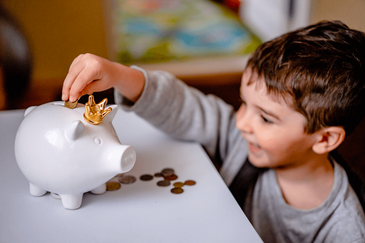 Saving Money With Mediation Image of a happy boy with a piggy bank