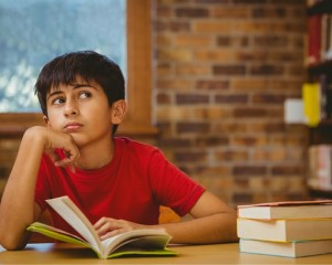Little boy reading and thinking