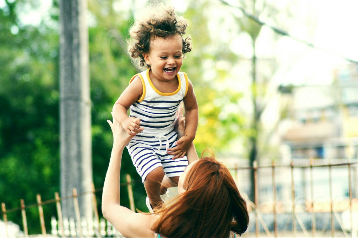This is a mother throwing her daughter in the air