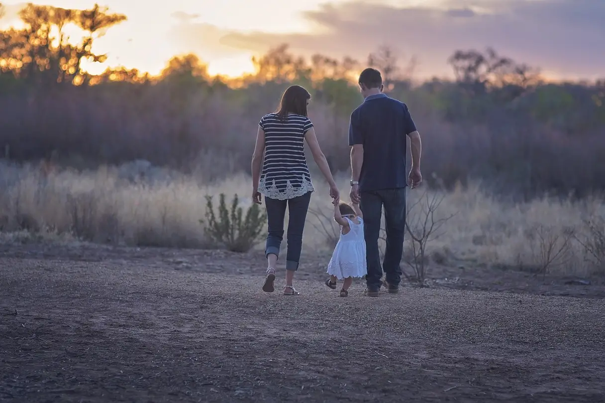 Healthy Co-parenting This is a photo of two parents walking with their child.