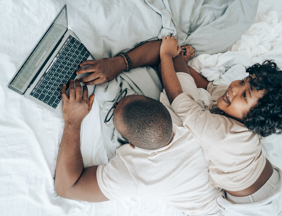  This is an image of a father working on a laptop with his child.