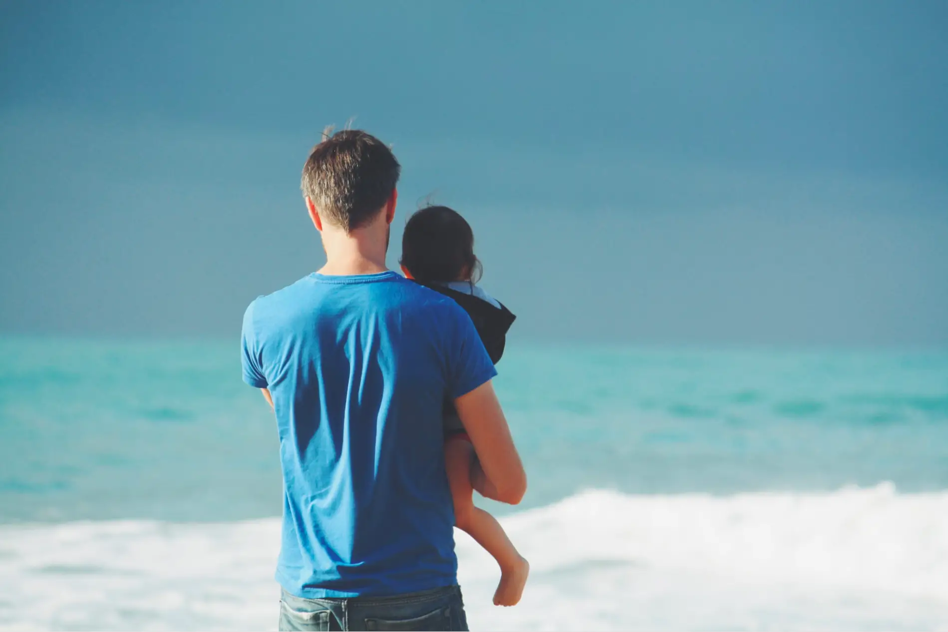 This is an image of a parent with their child at the beach.