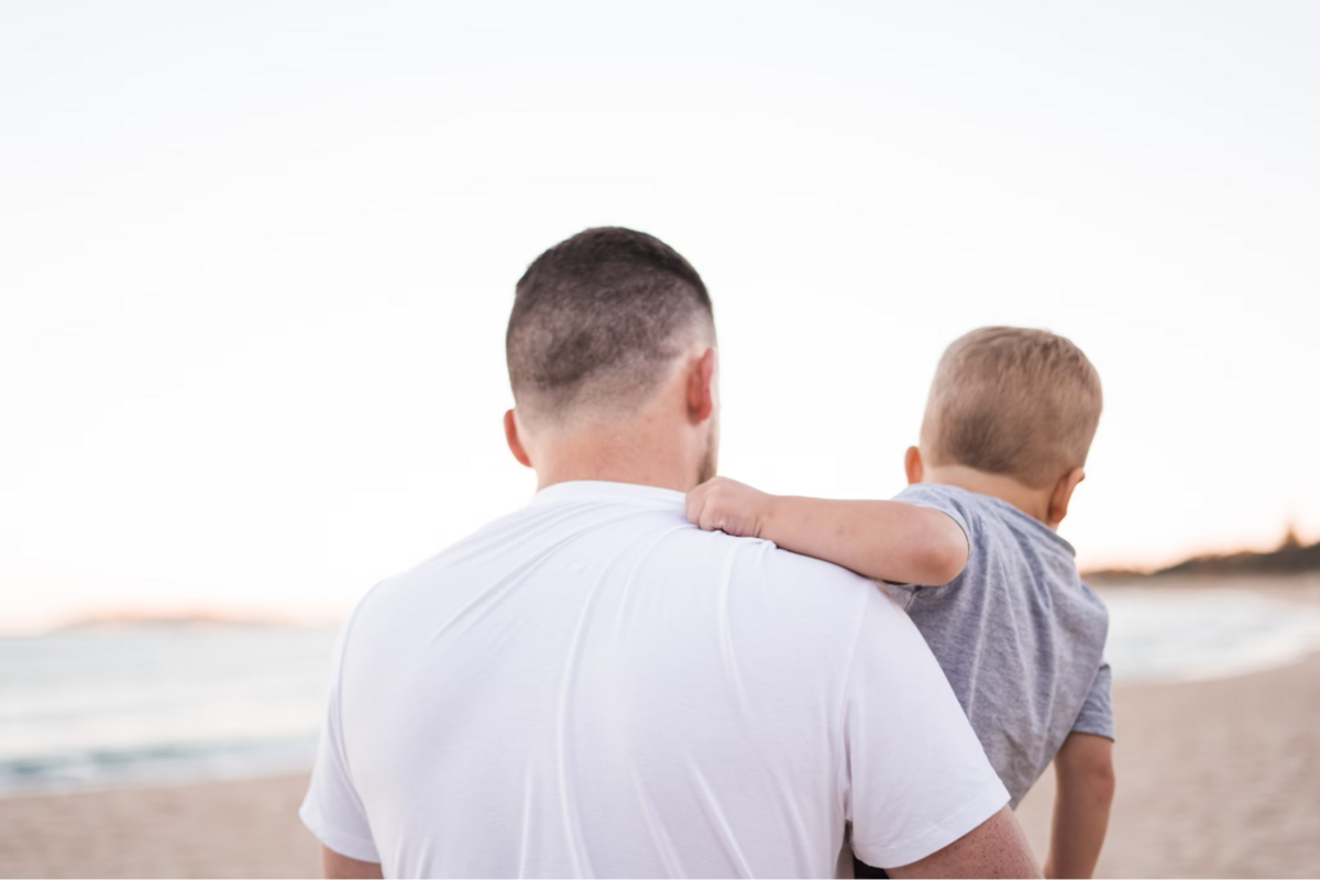 A father walking while holding his child.
