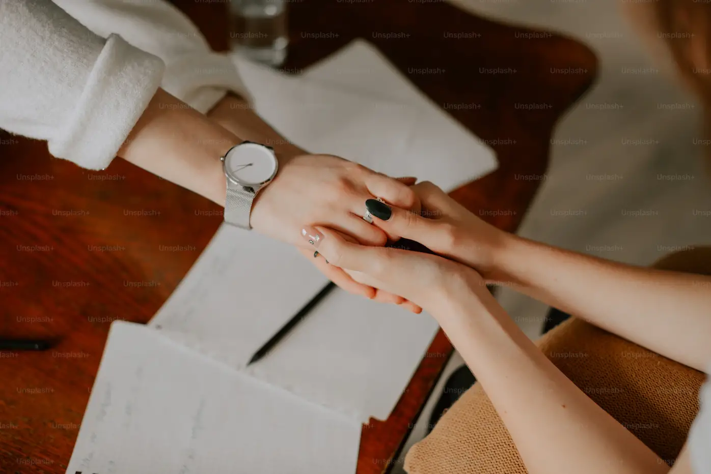 This is an image of a person holding someone's hands to support them.