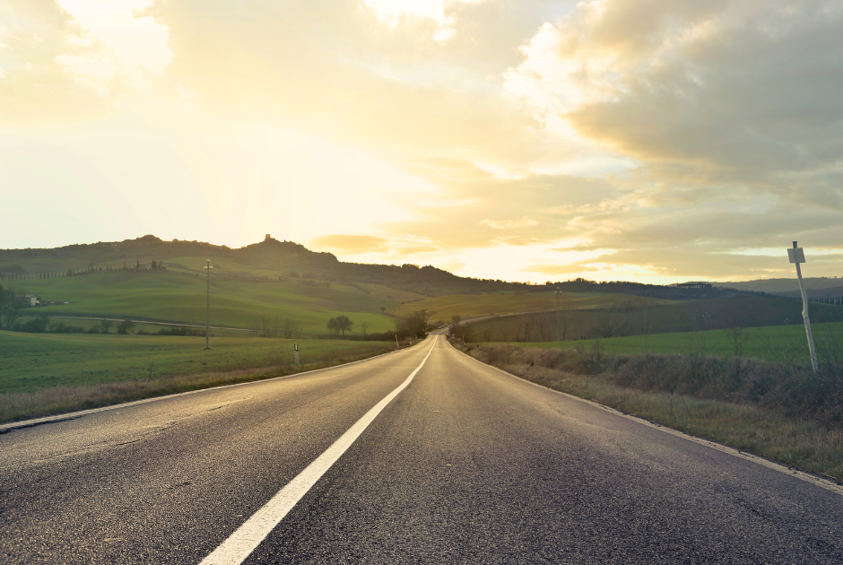 This is an image of a country road at sunset, with the road extending into the distance.