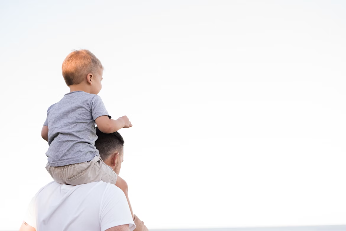 This is an image of a young child on their father's shoulders