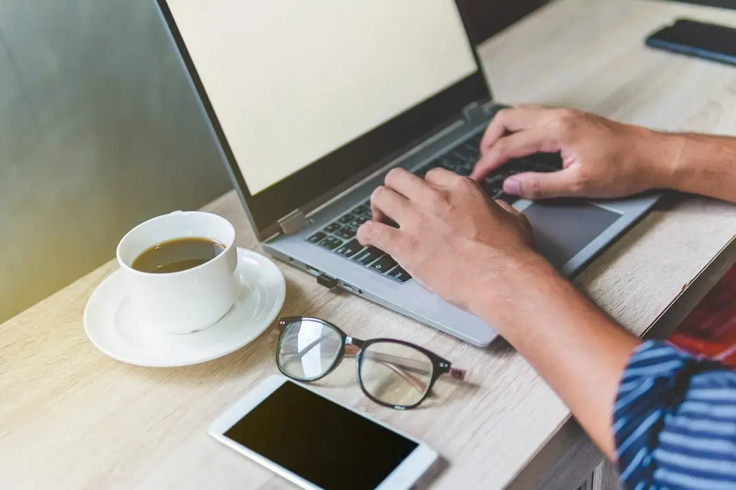This is an image of a person typing on a laptop.